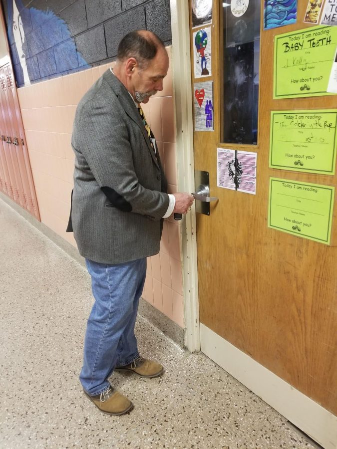 Mr. Campbell tests a door for security.