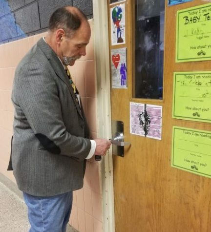 Mr. Campbell tests a door for security.